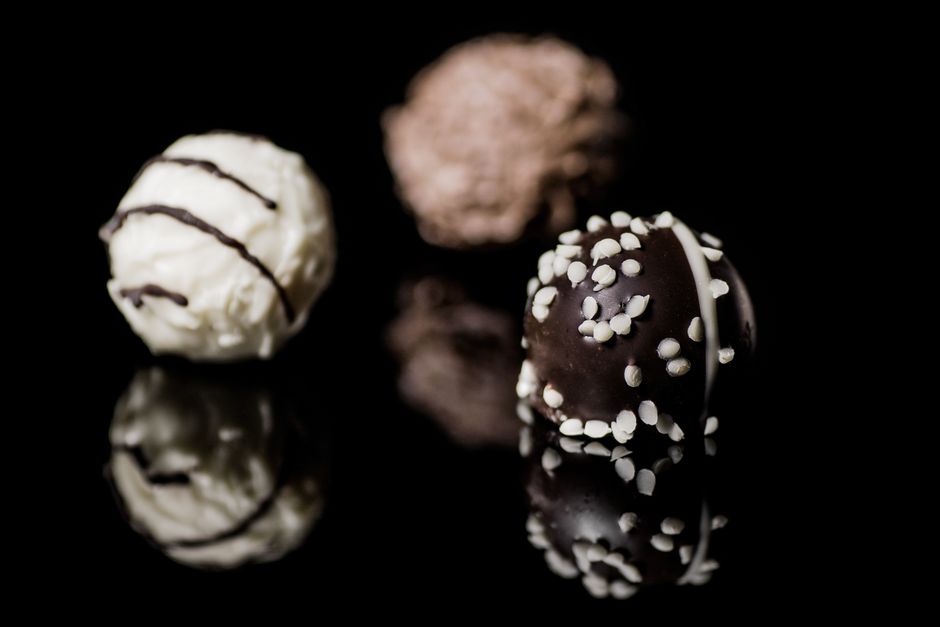 A row of handmade pralines dusted with cocoa